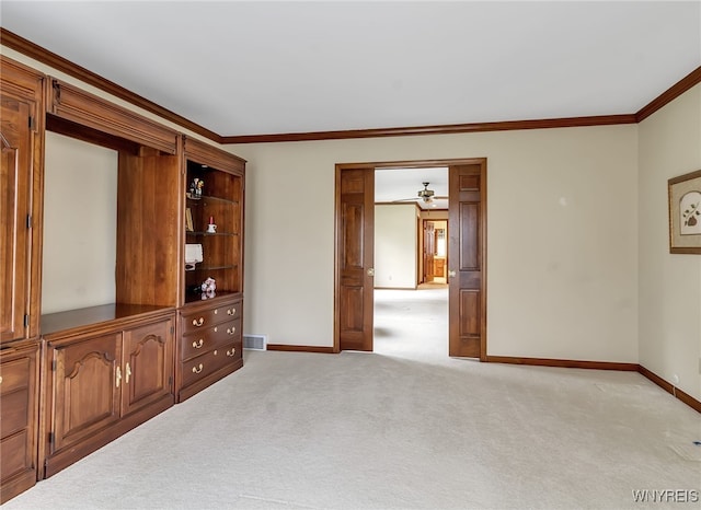 spare room featuring baseboards, ornamental molding, a ceiling fan, and light colored carpet
