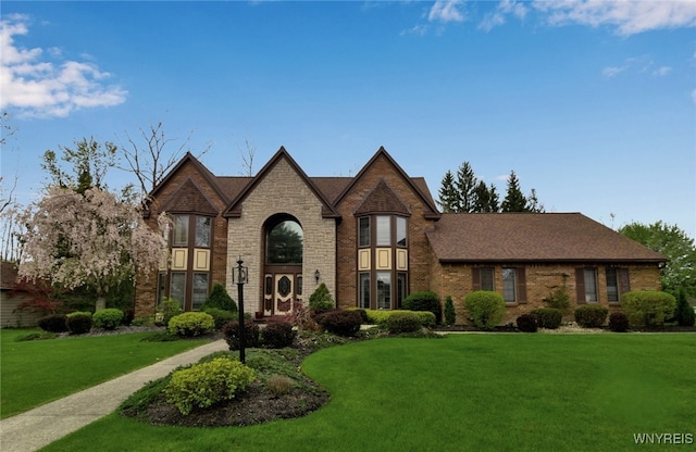 view of front of house featuring a front lawn, brick siding, and stone siding