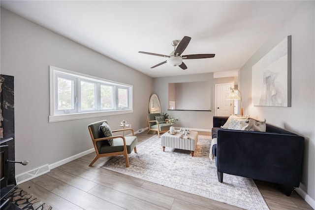 sitting room featuring wood finished floors, ceiling fan, and baseboards