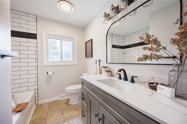 bathroom with toilet, vanity, and baseboards