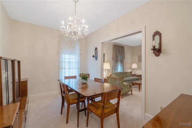 dining area with light carpet, a chandelier, and baseboards