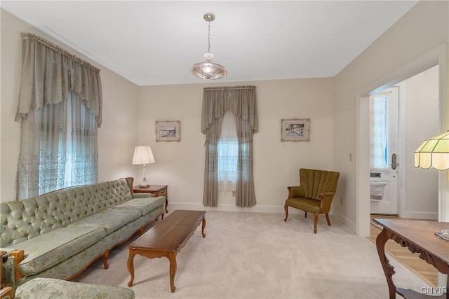 living area with plenty of natural light, carpet, and baseboards