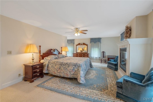 carpeted bedroom with baseboards, a ceiling fan, and a fireplace