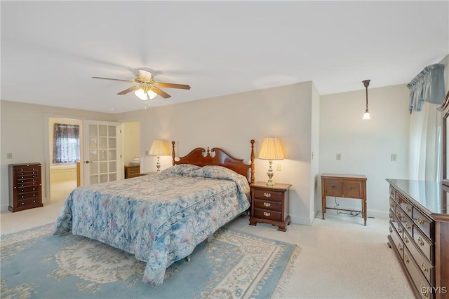 bedroom with light colored carpet, baseboards, ensuite bathroom, and ceiling fan