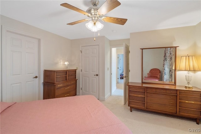 bedroom with light colored carpet, a ceiling fan, and baseboards