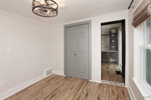 113 Olmstead Pl, Onondaga, NY 13219 - unfurnished bedroom with light wood-type flooring, baseboards, ornamental molding, a closet, and a chandelier