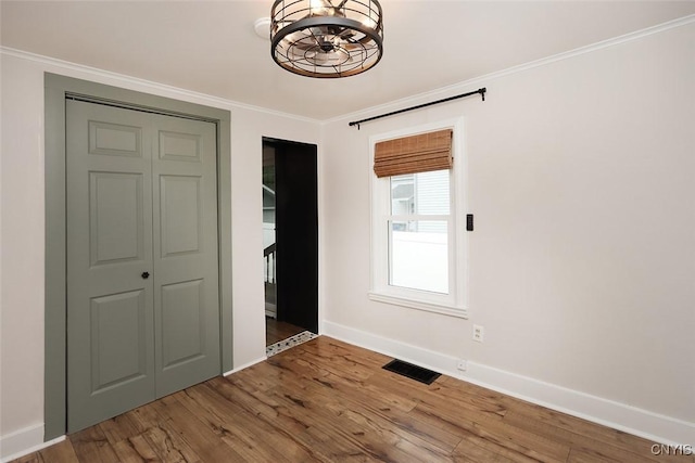 113 Olmstead Pl, Onondaga, NY 13219 - unfurnished bedroom with a chandelier, baseboards, wood finished floors, and crown molding