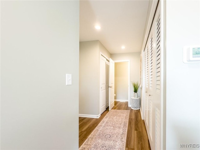 hall with recessed lighting, dark wood-style floors, and baseboards