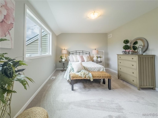 bedroom featuring baseboards, light colored carpet, and lofted ceiling
