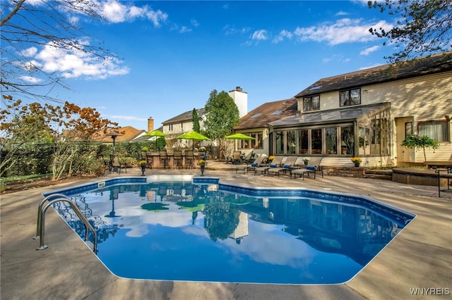 swimming pool featuring a patio and a sunroom