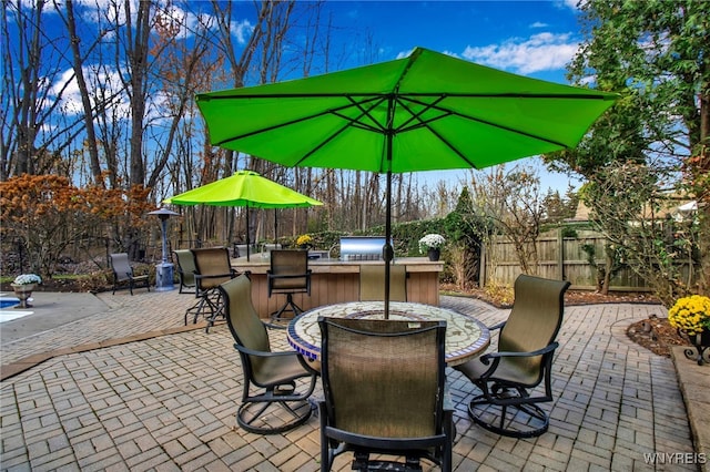 view of patio / terrace with exterior kitchen, a fenced backyard, and outdoor dining space