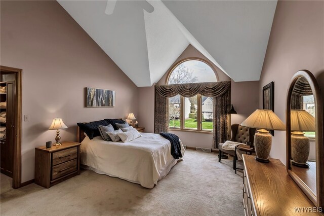 bedroom featuring light colored carpet, high vaulted ceiling, baseboards, and a ceiling fan
