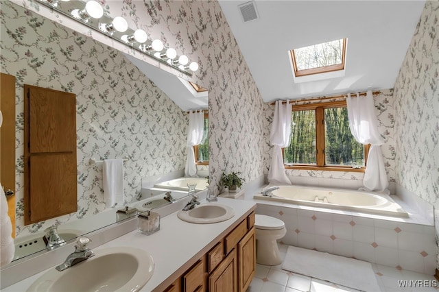 bathroom featuring wallpapered walls, a skylight, a garden tub, tile patterned flooring, and double vanity