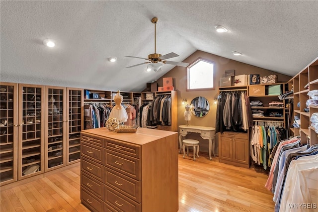 spacious closet featuring light wood-style floors, vaulted ceiling, and ceiling fan