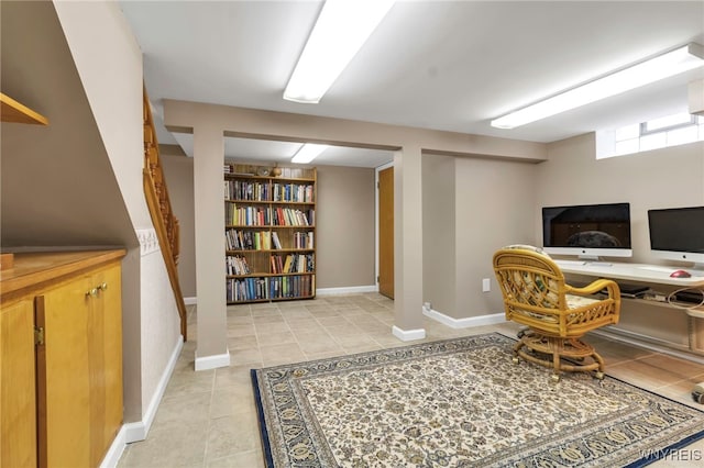 office area with light tile patterned flooring, built in shelves, and baseboards
