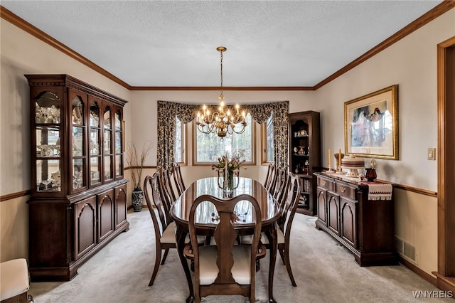 dining room featuring a chandelier, light carpet, a textured ceiling, crown molding, and baseboards