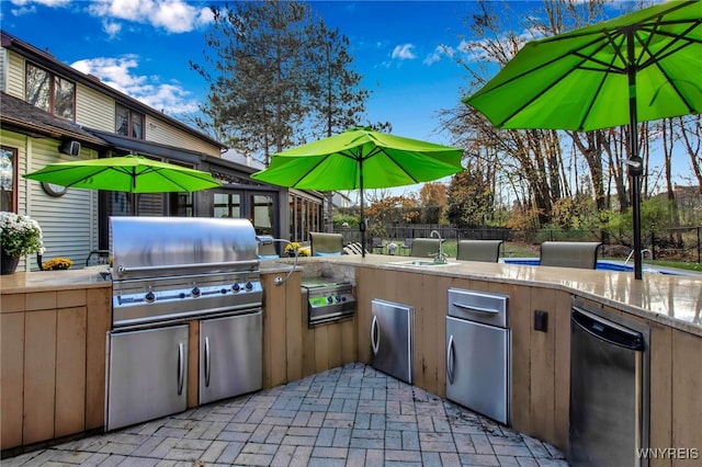 view of patio with a sink, exterior kitchen, fence, and a grill