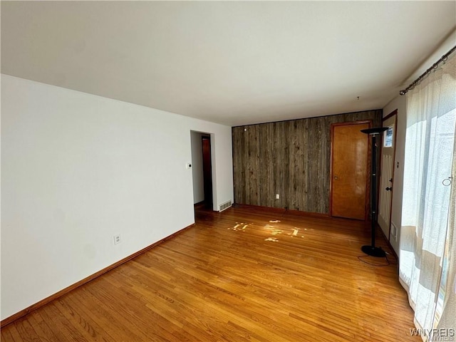 88 Loretto Dr, Cheektowaga, NY 14225 - spare room featuring light wood-style floors, wood walls, and baseboards