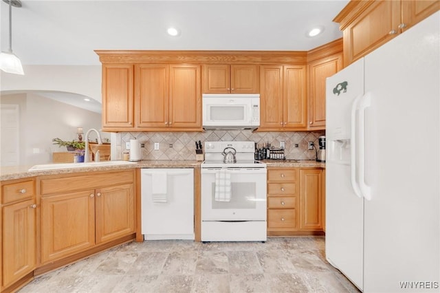 kitchen with white appliances, a sink, decorative backsplash, arched walkways, and recessed lighting