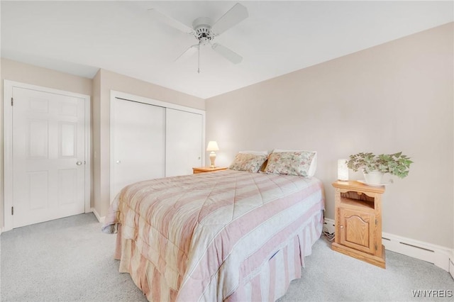 bedroom featuring light colored carpet, a closet, a baseboard heating unit, baseboards, and ceiling fan