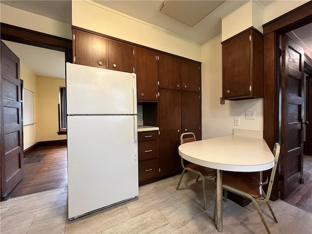 324 W Ave, Elmira-City, NY 14904 - kitchen with freestanding refrigerator, light countertops, dark brown cabinets, and a peninsula