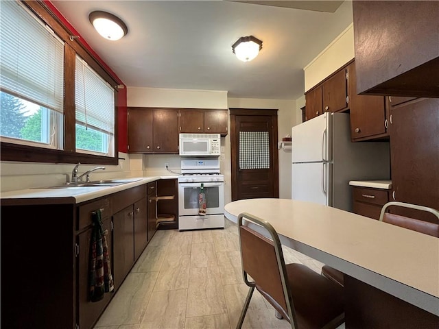 324 W Ave, Elmira-City, NY 14904 - kitchen with white appliances, a sink, light countertops, dark brown cabinets, and a kitchen bar