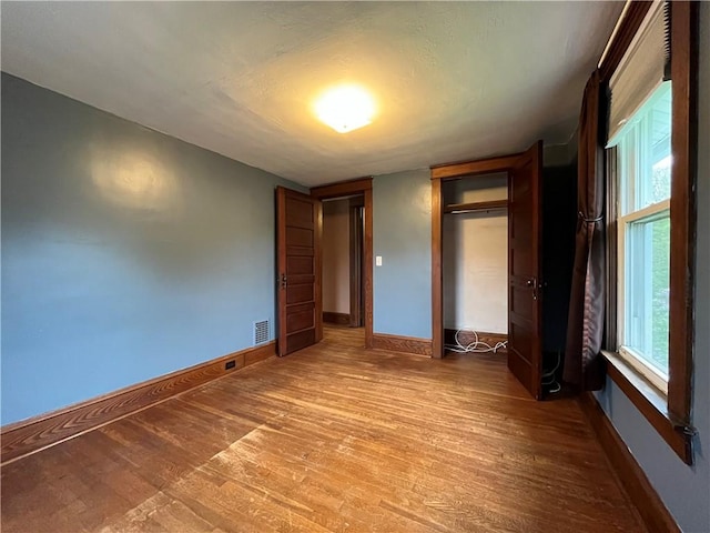 324 W Ave, Elmira-City, NY 14904 - unfurnished bedroom with wood finished floors, baseboards, and a closet