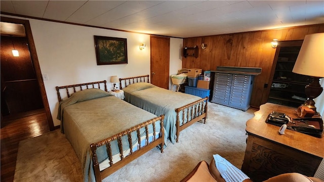 bedroom with carpet flooring, wood walls, and access to exterior