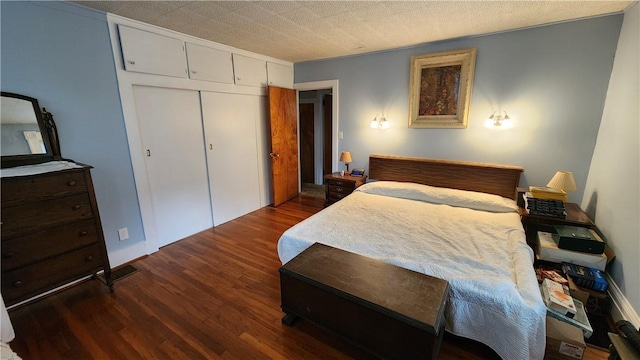 bedroom featuring dark wood-type flooring and a closet