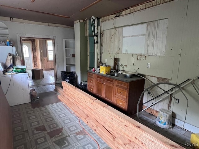 109 Mechanic St, Antwerp, NY 13608 - kitchen featuring brown cabinets, dark countertops, a sink, and dark flooring