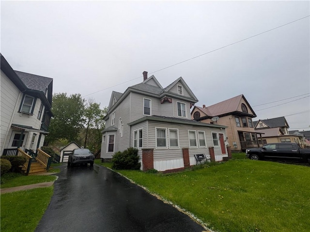 view of home's exterior with a yard, a detached garage, and driveway