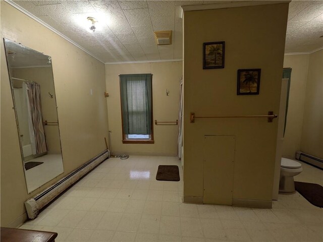 foyer featuring ornamental molding, light flooring, a baseboard heating unit, and baseboards