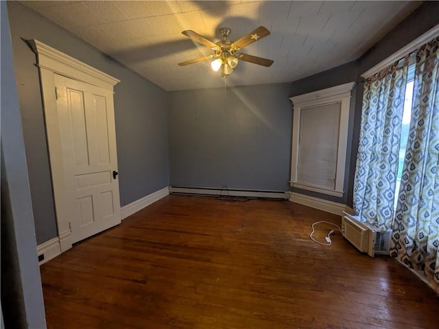 spare room with baseboard heating, wood finished floors, a ceiling fan, a wall mounted air conditioner, and baseboards