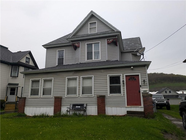 back of house featuring entry steps and a lawn