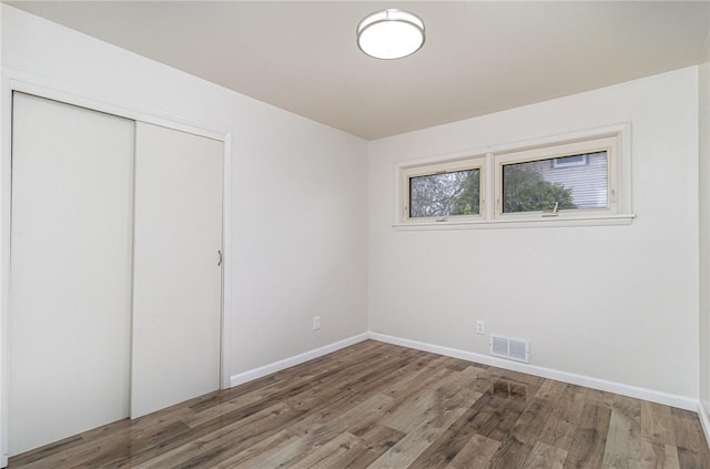 134 Schum Ln, Rochester, NY 14609 - unfurnished bedroom with wood finished floors, a closet, and baseboards