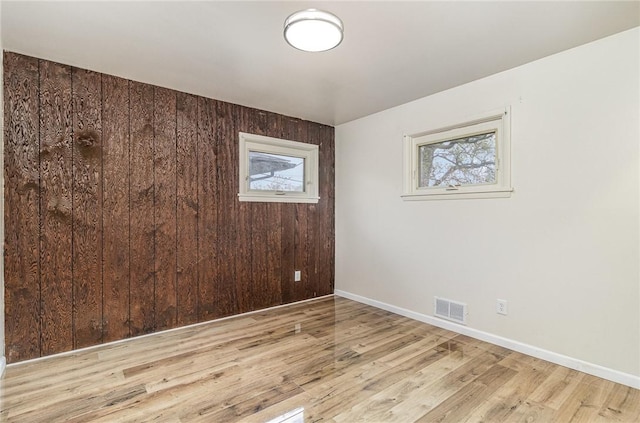 134 Schum Ln, Rochester, NY 14609 - empty room featuring healthy amount of natural light, wood finished floors, baseboards, and wood walls
