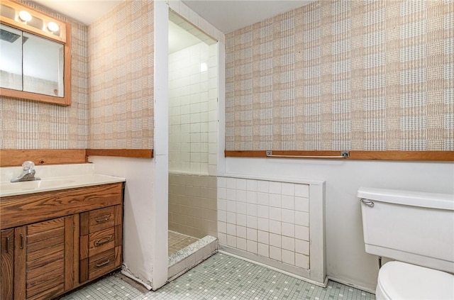 134 Schum Ln, Rochester, NY 14609 - full bathroom with toilet, tile patterned floors, a tile shower, vanity, and wallpapered walls