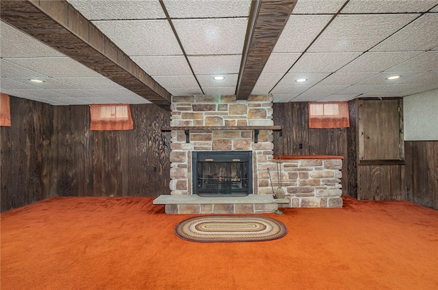 134 Schum Ln, Rochester, NY 14609 - carpeted living room featuring wood walls, a stone fireplace, and recessed lighting