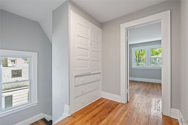 hallway featuring light wood-style floors and baseboards