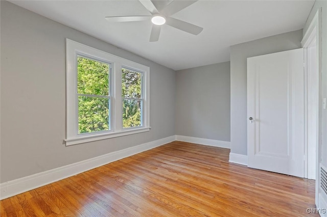 empty room with baseboards, light wood-type flooring, and a ceiling fan