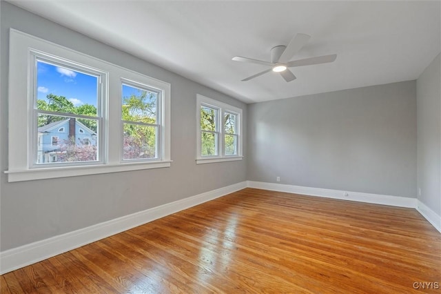 empty room featuring baseboards, light wood-style flooring, and ceiling fan