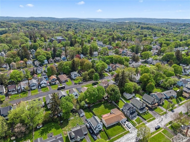 aerial view of property's location with nearby suburban area and a heavily wooded area