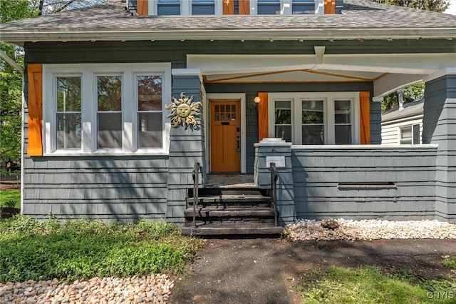 doorway to property with roof with shingles and covered porch