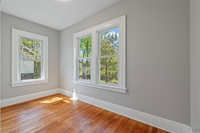 empty room with baseboards and light wood-style flooring