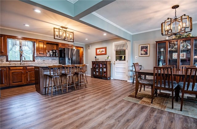 7732 Gifford Rd, Rome-Inside, NY 13440 - kitchen featuring refrigerator with ice dispenser, a chandelier, a center island, wood finished floors, and a kitchen breakfast bar