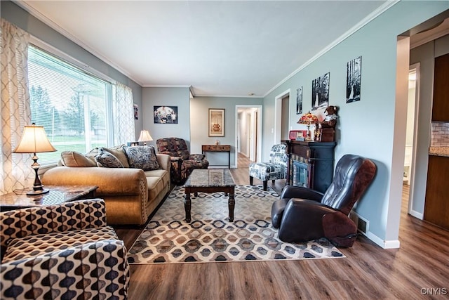 7732 Gifford Rd, Rome-Inside, NY 13440 - living area with wood finished floors, crown molding, a glass covered fireplace, and baseboards