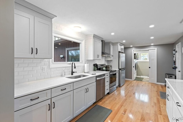 117 Shoreview Dr, Clay, NY 13090 - kitchen featuring stainless steel appliances, decorative backsplash, a sink, light wood-style flooring, and wall chimney range hood