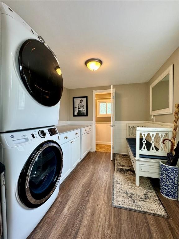 155 Hickory Grove Rd, Horseheads, NY 14845 - clothes washing area featuring stacked washer / drying machine, wood finished floors, cabinet space, and wainscoting