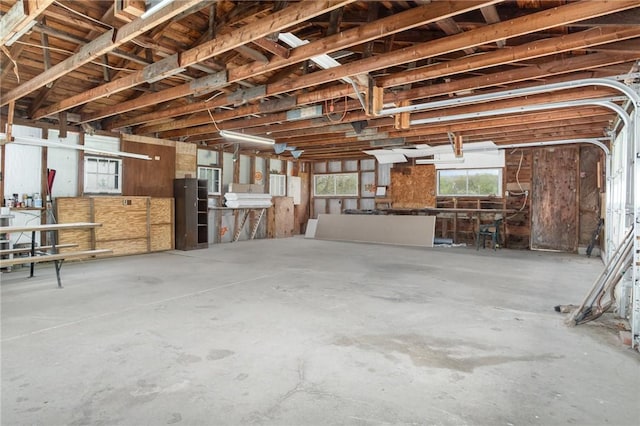 miscellaneous room with a garage and unfinished concrete flooring