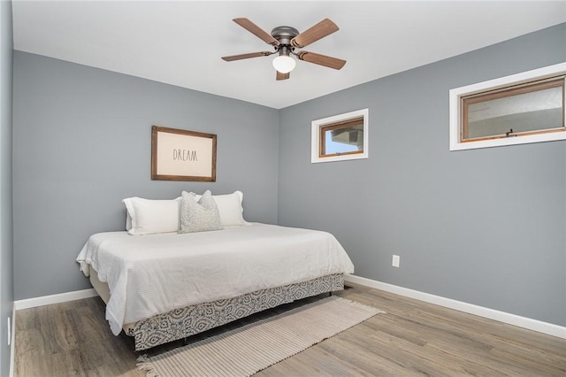 bedroom with baseboards, wood finished floors, and ceiling fan